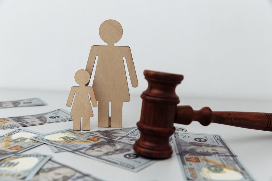 Figurines of a woman and a child stand on a table near the judge's gavel